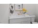 Charming bathroom features white vanity with gold fixtures, white marble countertop and decorative yellow orchids at 337 Merrywood Dr, Raleigh, NC 27610