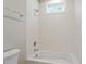 Bathroom showcasing a white bathtub with tiled walls and a window providing natural light at 337 Merrywood Dr, Raleigh, NC 27610