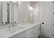 Bathroom with dual sinks, a white countertop, and a door leading to a separate toilet room at 337 Merrywood Dr, Raleigh, NC 27610