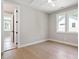 Sunlit bedroom with hardwood floors, a ceiling fan, and a view of lush greenery through the large windows at 337 Merrywood Dr, Raleigh, NC 27610
