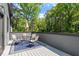Outdoor deck with a table, chairs, and a blue rug in a wooded setting at 337 Merrywood Dr, Raleigh, NC 27610