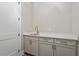 Laundry room featuring light gray cabinets, a white countertop, and decorative floor tiles at 337 Merrywood Dr, Raleigh, NC 27610