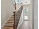 Elegant staircase with hardwood steps, a dark metal railing, and a bright entry at 337 Merrywood Dr, Raleigh, NC 27610