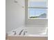 Bright bathroom features a soaking tub with chrome fixtures and a view from the window at 367 Fenella Dr, Four Oaks, NC 27524
