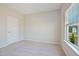 A well lit bedroom includes a window, neutral carpet, and a door at 367 Fenella Dr, Four Oaks, NC 27524