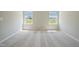 An empty bedroom with carpet and two windows allowing for lots of natural light at 367 Fenella Dr, Four Oaks, NC 27524