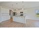 Kitchen with stainless steel appliances, white cabinets, granite countertops, and wood flooring at 367 Fenella Dr, Four Oaks, NC 27524