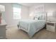 Airy bedroom features soft blue bedding and decor, creating a serene atmosphere, enhanced by natural light from the window at 368 N Coral Bells Way, Four Oaks, NC 27524
