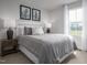 Bright bedroom featuring a bed with soft gray linens and decorative pillows, enhanced by natural light from the window at 368 N Coral Bells Way, Four Oaks, NC 27524