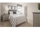 Neutral bedroom featuring a bed with striped bedding, complemented by minimalist decor, creates a modern and serene ambiance at 368 N Coral Bells Way, Four Oaks, NC 27524