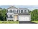 Charming two-story home features a two-car garage, yellow front door, and black shutters at 368 N Coral Bells Way, Four Oaks, NC 27524
