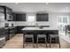 Modern kitchen featuring black cabinetry, stainless steel appliances, and a spacious island with barstool seating at 368 N Coral Bells Way, Four Oaks, NC 27524