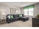 Cozy living room is furnished with a comfortable gray sectional sofa and bright green accents, perfect for relaxation at 368 N Coral Bells Way, Four Oaks, NC 27524