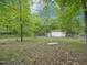 The backyard features a shed, potential chicken coop, and abundant trees at 3806 Sue Ln, Raleigh, NC 27604