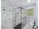 Modern bathroom featuring a frameless glass shower with stylish marble tile and updated fixtures at 3806 Sue Ln, Raleigh, NC 27604