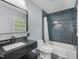 Bathroom featuring a black countertop, modern fixtures and a beautifully tiled shower and bathtub at 3806 Sue Ln, Raleigh, NC 27604
