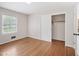 Cozy bedroom showcasing hardwood floors, closet with sliding doors, and a window at 3806 Sue Ln, Raleigh, NC 27604