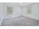 Spacious bedroom with plush carpet, two windows, and neutral color palette at 3806 Sue Ln, Raleigh, NC 27604