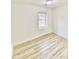 Bright bedroom featuring light-colored walls, new floors and a window with natural light at 409 Neathery St, Henderson, NC 27536