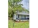 Side view of home with a cozy front porch, lush lawn and landscaping featuring a well-maintained exterior at 409 Neathery St, Henderson, NC 27536