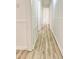 Hallway featuring light-colored walls, new floors and doors to other rooms at 409 Neathery St, Henderson, NC 27536