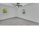 A bright bedroom features a ceiling fan, neutral carpet, two windows and white walls at 419 Joy Dr, Garner, NC 27529