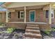 Charming brick home features a covered front porch and a teal-colored front door, enhancing its curb appeal at 419 Joy Dr, Garner, NC 27529