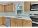Bright kitchen with new stainless steel appliances, light wood cabinets, and a gorgeous tile backsplash at 419 Joy Dr, Garner, NC 27529