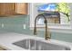 Close-up of a kitchen sink featuring stainless steel basin, light countertops and matching cabinets at 419 Joy Dr, Garner, NC 27529