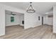 Open-concept living room with wood-look flooring, wainscoting, and chandelier lighting at 419 Joy Dr, Garner, NC 27529
