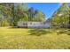 Backyard view of house, large yard, and white porch under a blue sky at 4500 Governor Hunt St, Efland, NC 27243