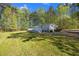 Backyard view of house with white deck and yard, surrounded by mature trees at 4500 Governor Hunt St, Efland, NC 27243