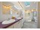 Bright bathroom featuring a double vanity, skylight, soaking tub, and separate shower at 4500 Governor Hunt St, Efland, NC 27243