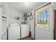 Convenient laundry area with appliances, storage shelves, and easy access to the outdoors at 4500 Governor Hunt St, Efland, NC 27243