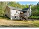 Large backyard with mature trees, two-story home, and a playset at 452 Dogwood Trl, Henderson, NC 27537