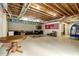 Unfinished basement space with exposed beams, a finished room, and various storage at 452 Dogwood Trl, Henderson, NC 27537