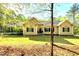 Charming single story home featuring a landscaped lawn, symmetrical windows, and a comfortable covered carport at 452 Dogwood Trl, Henderson, NC 27537