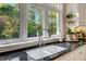 Granite counter tops surround the dual basin kitchen sink overlooking a scenic outdoor view at 452 Dogwood Trl, Henderson, NC 27537