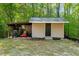 Functional outbuilding for storage or hobbies, complete with a covered area for equipment and tools at 452 Dogwood Trl, Henderson, NC 27537