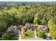 Aerial view featuring well-manicured lawns, lush trees, and stately homes in a desirable neighborhood with a pond at 5016 Dillswood Ln, Raleigh, NC 27606