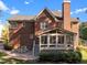 Exterior view of brick home featuring sunroom, brick patio, and large backyard at 5016 Dillswood Ln, Raleigh, NC 27606