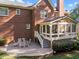 Brick home features a stone patio with seating and a cozy sunroom addition at 5016 Dillswood Ln, Raleigh, NC 27606