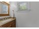 Bathroom vanity with a window that provides natural light, granite countertop and wood cabinets at 5016 Dillswood Ln, Raleigh, NC 27606