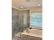 Bathroom featuring glass shower, a separate soaking tub, and a large window at 5016 Dillswood Ln, Raleigh, NC 27606