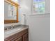 Charming bathroom with granite counters, a wooden framed mirror, and a bright window at 5016 Dillswood Ln, Raleigh, NC 27606