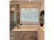 Bright bathroom featuring a glass shower, soaking tub, and a view from the window at 5016 Dillswood Ln, Raleigh, NC 27606