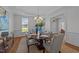 Elegant dining room with a decorative light fixture, table setting and large windows for natural light at 5016 Dillswood Ln, Raleigh, NC 27606