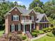 Stunning two-story brick home with elegant architectural details, a charming balcony, and landscaped garden at 5016 Dillswood Ln, Raleigh, NC 27606