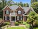 Close-up of a beautiful brick home featuring a small balcony and manicured landscaping at 5016 Dillswood Ln, Raleigh, NC 27606