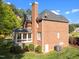 Brick home showing the back exterior with patio, sunroom, and chimney at 5016 Dillswood Ln, Raleigh, NC 27606